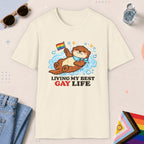 Natural color all-gender graphic t-shirt with "Otter Living Best Gay Life" design