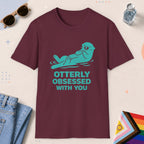 Maroon color all-gender graphic t-shirt with "Otterly Obsessed" design