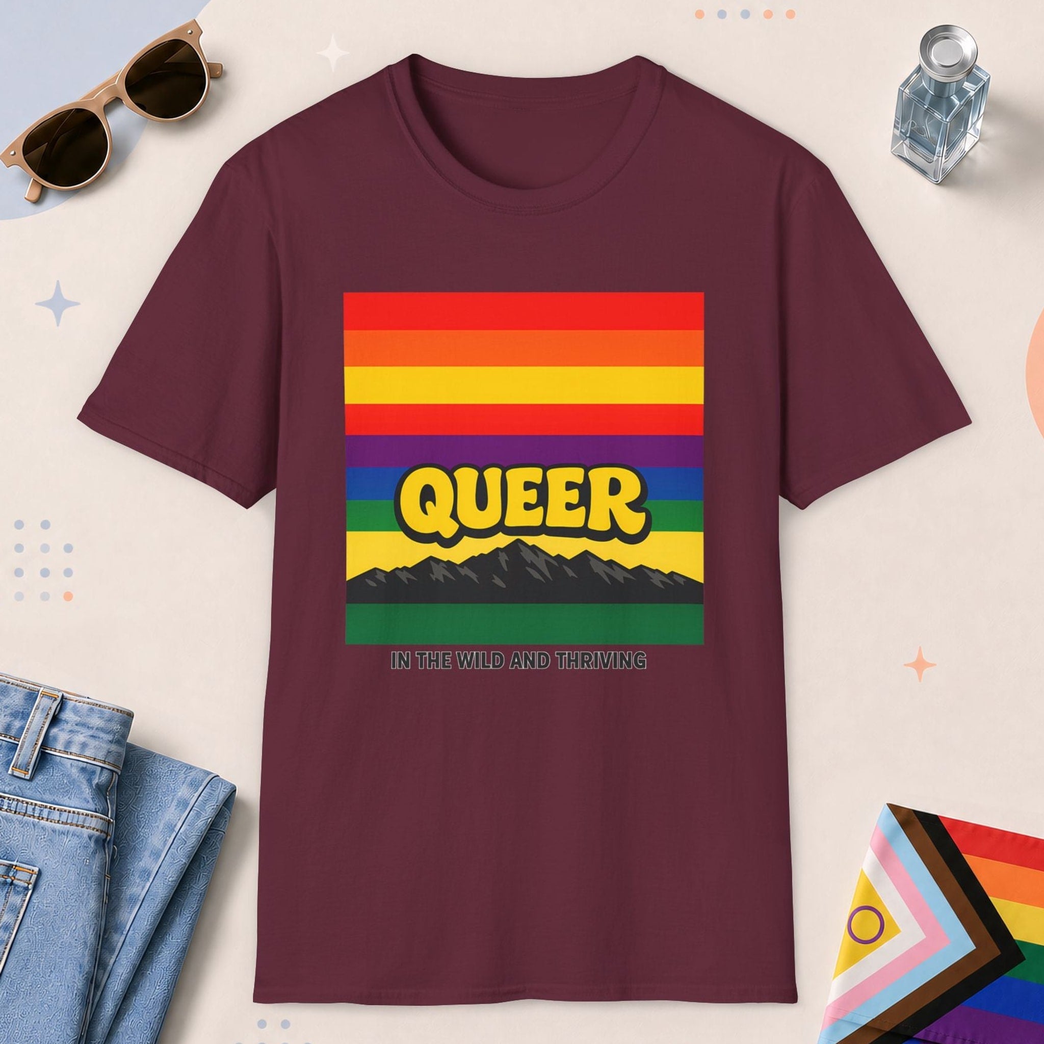 Maroon color all-gender graphic t-shirt with "Queer In The Wild" design